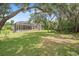Spacious backyard with mature trees and a screened-in pool area for outdoor enjoyment at 1766 Roscoe Turner Trl, Port Orange, FL 32128