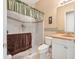 Bathroom with white tiled shower, decorated with patterned border and tan colored walls and vanity at 1766 Roscoe Turner Trl, Port Orange, FL 32128