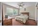 Cozy bedroom featuring a queen-size bed, a large window, and a ceiling fan at 1766 Roscoe Turner Trl, Port Orange, FL 32128