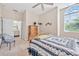 Bright bedroom with a large window, ceiling fan, and a door leading to a bathroom at 1766 Roscoe Turner Trl, Port Orange, FL 32128