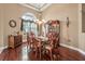 Formal dining room with hardwood floors, large window, chandelier and wood china cabinet at 1766 Roscoe Turner Trl, Port Orange, FL 32128