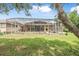 Exterior view of the home, highlighting the screened-in pool and spacious backyard at 1766 Roscoe Turner Trl, Port Orange, FL 32128