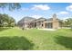 Expansive backyard features a screened-in pool, a spacious patio, and lush green lawn at 1766 Roscoe Turner Trl, Port Orange, FL 32128