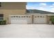 Home exterior with an attached three-car garage and an expansive driveway at 1766 Roscoe Turner Trl, Port Orange, FL 32128