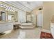 Luxurious main bathroom with a large soaking tub and glass block window at 1766 Roscoe Turner Trl, Port Orange, FL 32128