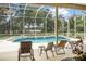 Screened-in pool area with lounge chairs, view of lake, and outdoor seating at 1766 Roscoe Turner Trl, Port Orange, FL 32128