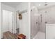 Modern bathroom featuring a glass-enclosed shower with multiple showerheads, alongside a hallway with wood-look floors at 3828 S Atlantic Ave, Daytona Beach, FL 32118