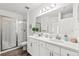 Bathroom showcasing double vanity sinks and a modern tiled shower at 3828 S Atlantic Ave, Daytona Beach, FL 32118