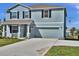 This two-story home has blue siding, a two-car garage, and a manicured lawn in a sunny location at 3828 S Atlantic Ave, Daytona Beach, FL 32118