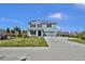 Attractive two-story blue home featuring a well-maintained lawn and a concrete driveway at 3828 S Atlantic Ave, Daytona Beach, FL 32118