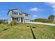 Inviting two-story blue home with a manicured lawn and mature landscaping on a sunny day at 3828 S Atlantic Ave, Daytona Beach, FL 32118