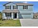 This two-story home features eye-catching blue siding, a two-car garage and a meticulously manicured lawn at 3828 S Atlantic Ave, Daytona Beach, FL 32118