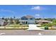 A two-story home with blue siding, a well-maintained lawn and a long driveway with landscaping at 3828 S Atlantic Ave, Daytona Beach, FL 32118