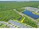 Aerial view showcases the home's location within the community, near a lake and wooded area at 5539 Estero Loop, Port Orange, FL 32128