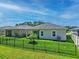 A spacious backyard featuring a lush lawn, decorative landscaping, and a secure black metal fence at 5539 Estero Loop, Port Orange, FL 32128