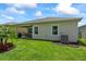 Lush backyard with covered patio, green lawn, and a palm tree at 5539 Estero Loop, Port Orange, FL 32128