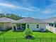 Features a well-kept lawn, patio set, grill, and landscaped garden enclosed by a black metal fence at 5539 Estero Loop, Port Orange, FL 32128