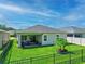 This yard features a green lawn, patio, grill, and secure black metal fence at 5539 Estero Loop, Port Orange, FL 32128