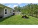 Beautiful fenced backyard features well-maintained lawn and landscaped garden with a palm tree at 5539 Estero Loop, Port Orange, FL 32128