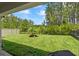 Expansive backyard featuring lush green grass, mature trees, and a black metal fence at 5539 Estero Loop, Port Orange, FL 32128