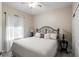 This bedroom features a queen size bed, light hardwood floors, a ceiling fan, and a large window at 5539 Estero Loop, Port Orange, FL 32128