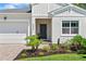 Inviting front entry with a dark-colored door, stone accents, and a well-maintained garden at 5539 Estero Loop, Port Orange, FL 32128