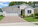 Charming single-story home with a well-manicured lawn, brick driveway, and attached two-car garage at 5539 Estero Loop, Port Orange, FL 32128