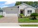 Charming single-story home with a well-manicured lawn, brick driveway, and attached two-car garage at 5539 Estero Loop, Port Orange, FL 32128