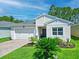 Charming single-story home with a well-manicured lawn, brick driveway, and attached two-car garage at 5539 Estero Loop, Port Orange, FL 32128