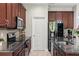 Kitchen featuring stainless steel appliances, granite countertops, and an adjacent door at 5539 Estero Loop, Port Orange, FL 32128