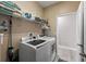 Well-organized laundry room with white washer and dryer, wire shelving, and neutral paint at 5539 Estero Loop, Port Orange, FL 32128
