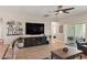 Comfortable living room with modern entertainment center, ceiling fan, and sliding glass doors at 5539 Estero Loop, Port Orange, FL 32128