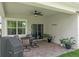 Cozy covered patio featuring a ceiling fan, brick pavers, and outdoor seating at 5539 Estero Loop, Port Orange, FL 32128
