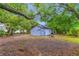 Backyard view shows the surrounding trees and blue exterior at 603 W Miles St, Deland, FL 32720