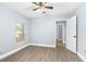 Bright bedroom features a ceiling fan, wood-look flooring, and natural light from the window at 603 W Miles St, Deland, FL 32720