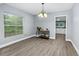 Bright dining room with large window, modern chandelier, and view to the kitchen at 603 W Miles St, Deland, FL 32720