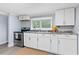 Well-lit kitchen featuring white cabinets, modern appliances, and stylish countertops at 603 W Miles St, Deland, FL 32720