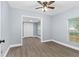 Bright living room with neutral gray walls, modern ceiling fan, and laminate floors at 603 W Miles St, Deland, FL 32720