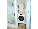Bathroom with standing shower, laundry, and wood shelves at 68 Hibiscus Dr, Ormond Beach, FL 32176