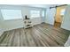 Bright bedroom featuring wood-look floors, a beverage station, and ensuite bathroom with sliding barn door at 68 Hibiscus Dr, Ormond Beach, FL 32176