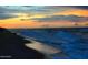 Calm ocean with waves under a vivid yellow and blue sunset at 68 Hibiscus Dr, Ormond Beach, FL 32176