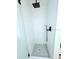 Modern shower with white subway tile and dark fixtures and pebble floor at 68 Hibiscus Dr, Ormond Beach, FL 32176