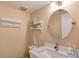 Cozy bathroom with a decorative shelf, round mirror, and light-toned walls at 1239 Ocean Shore Blvd # 11D, Ormond Beach, FL 32176