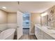 Elegant bathroom with a freestanding tub, luxurious vanity, and an open doorway to the main bedroom at 1239 Ocean Shore Blvd # 11D, Ormond Beach, FL 32176