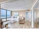 Cozy living room with a plush sofa, floor-to-ceiling windows offering panoramic views of the ocean at 1239 Ocean Shore Blvd # 11D, Ormond Beach, FL 32176