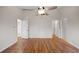 Bright bedroom featuring hardwood floors, white walls, ceiling fan, and multiple doorways leading to other rooms at 1317 Northside Dr, Ormond Beach, FL 32174
