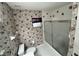 This bathroom features a floral wallpaper, toilet, shower, and window at 16 Hunt Master Ct, Ormond Beach, FL 32174
