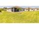 View of the property's spacious backyard with well-maintained lawn and young palm trees at 2840 Monaghan Dr, Ormond Beach, FL 32174