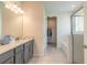 Well-lit bathroom featuring double vanity, tile floors, and walk-in closet access at 2840 Monaghan Dr, Ormond Beach, FL 32174