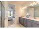 Bathroom featuring a double vanity, gray cabinetry, and a view into the light-filled bedroom at 2840 Monaghan Dr, Ormond Beach, FL 32174